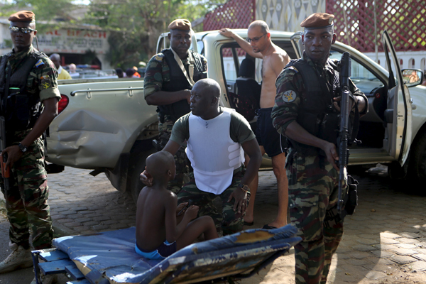 A soldier comforts an injured boy in Bassam, Ivory Coast, on Sunday (Reuters photo)